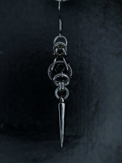 Silver pendant with a sharp point on a dark background