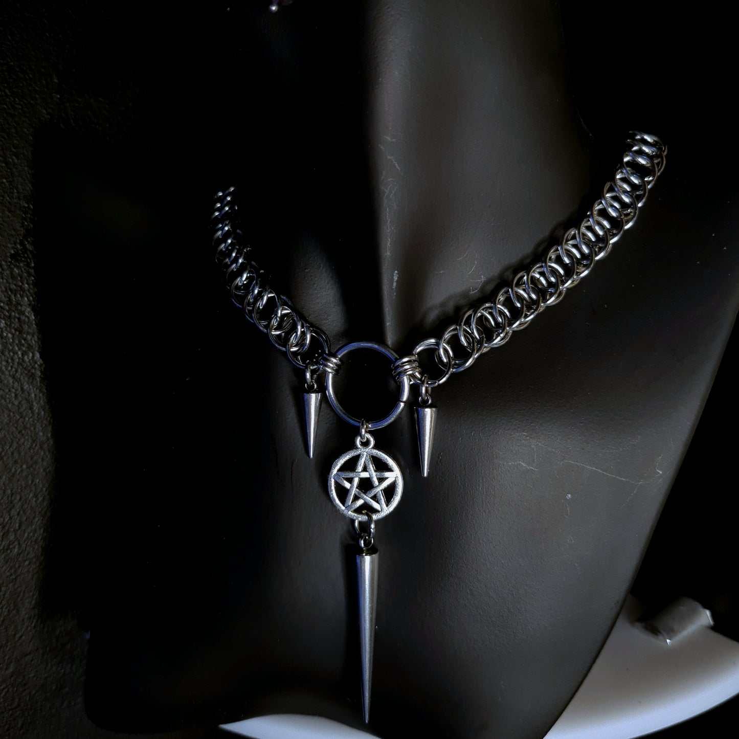 Necklace with pentagram pendant and spikes on a black background