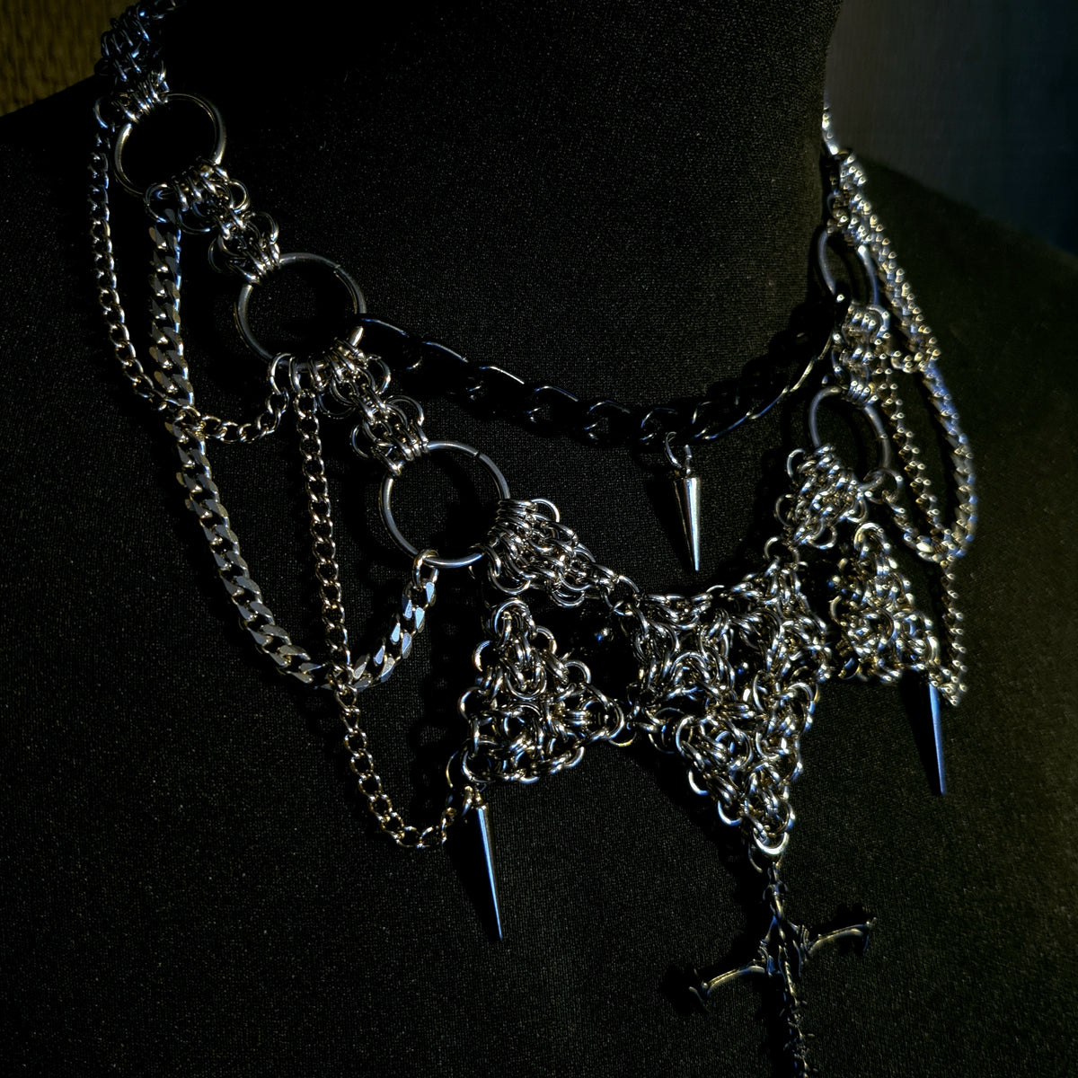 gothic alternative necklace with chain and spike design on a black background with cross