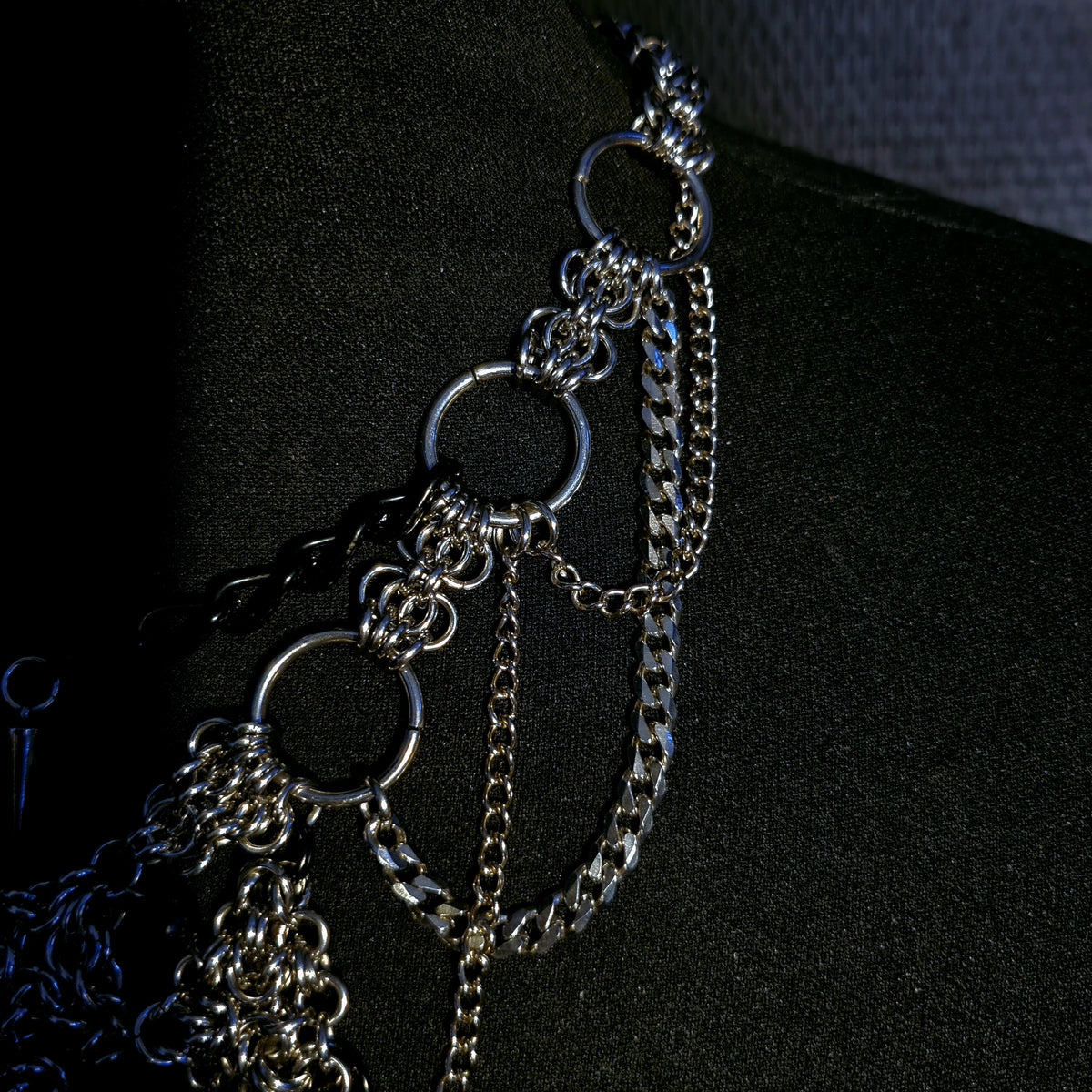 Close-up of an alternative gothic silver chain necklace on a black background