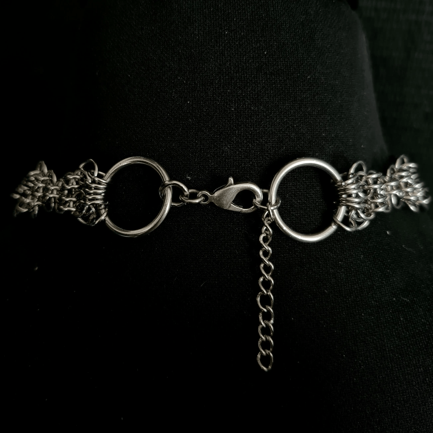 Silver chain necklace on a black background showing lobster clasp
