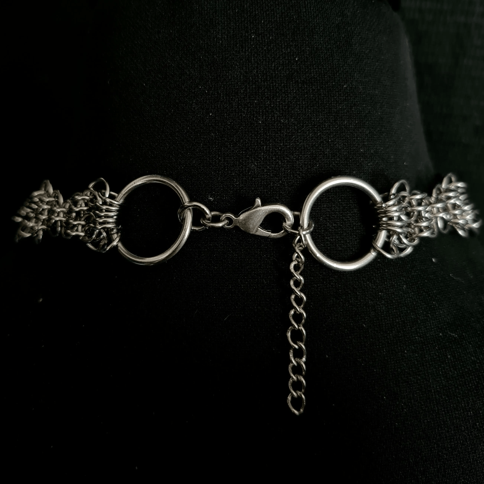 Silver chain necklace on a black background showing lobster clasp