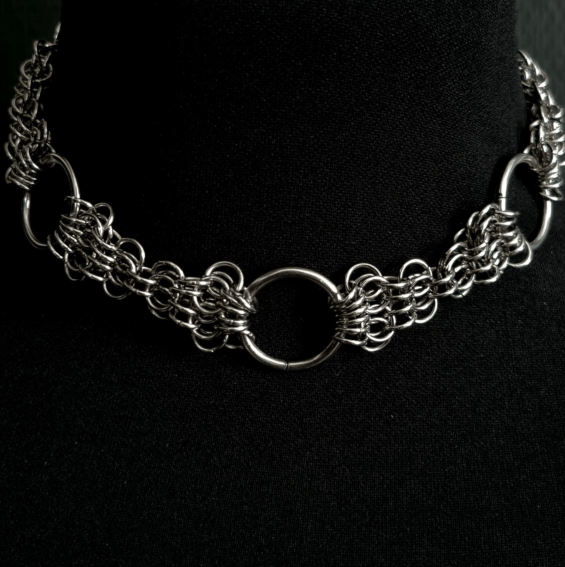 Silver chain necklace on a black background